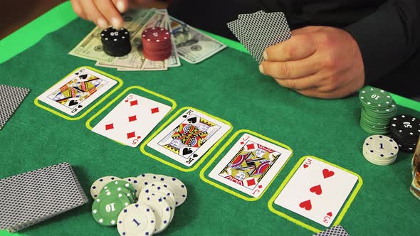 Closeup Hands of a Risky Poker Player are Slowly Picking Up and Moving Chips