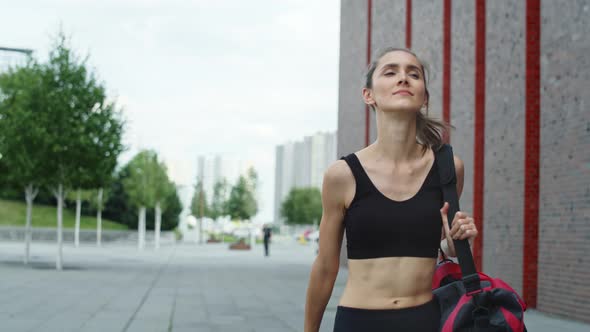 Video of woman walking in a training outfit in the city. Shot with RED helium camera in 8K. 