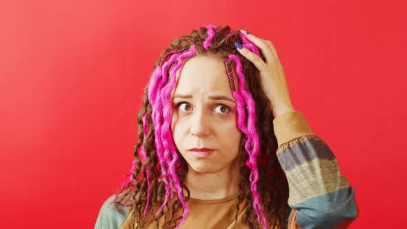 Young Thoughtful Woman Scratching Head on Red Background