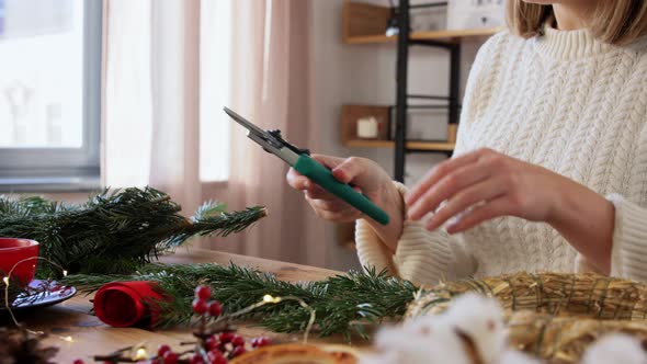 Happy Woman Making Fir Christmas Wreath at Home