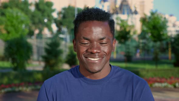 Close Up Smiling Afroamerican Man Looks Camera on Background Park in Summer