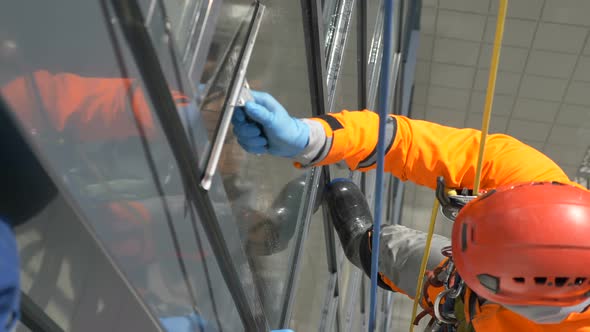 Industrial Climber in Orange Suit Washes Windows During Latex Glove Pandemic of Coronovirus