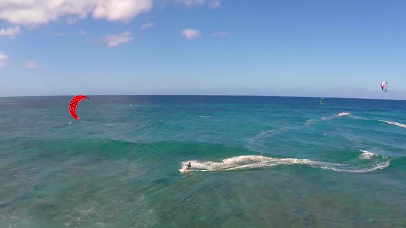 Aerial view of a man kitesurfing in Hawaii.