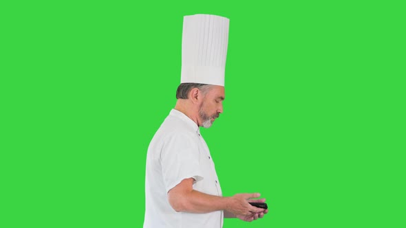 Bearded Man Cook Walking and Using Mobile Phone on a Green Screen Chroma Key