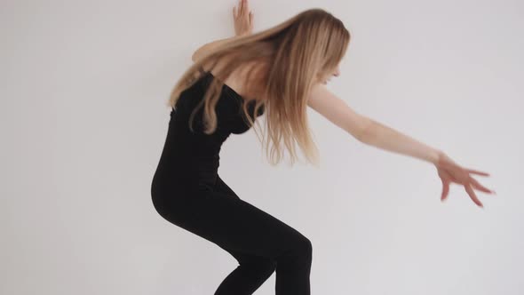 Sensual Young Girl Stretches in a White Studio and Moves Smoothly Using Elements of Classical Dance