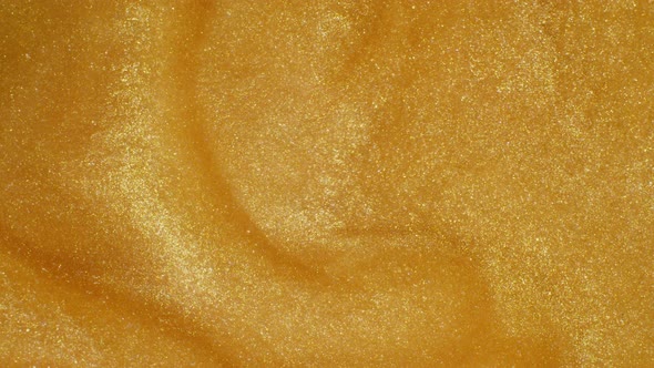 Macro shot of gold glitter. Slow mo. Amazing background. 4K. Gold liquid. Boke.