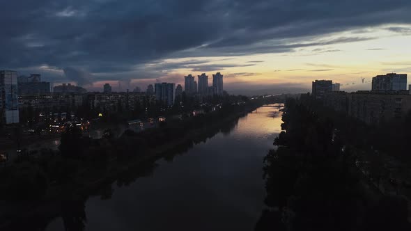 Aerial View of Dark Rainy City Traffic After Sunset Water Canal Between Two Avenues and Residential