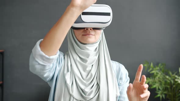 Slow Motion of Cheerful Middle Eastern Woman in Hijab Using Virtual Reality Glasses Moving Arms at