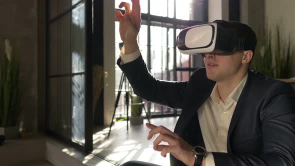 businessman working in virtual reality glasses sitting in a stylish sunny office