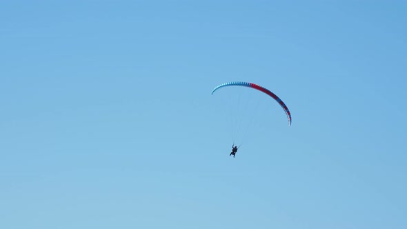 Tourist with Instructor Hovering in the Sky on a Paraglider. Tourist Attraction Over Rose Peak Cable