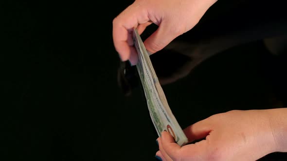 Closeup of Businesswoman Folds a Stack of Dollars
