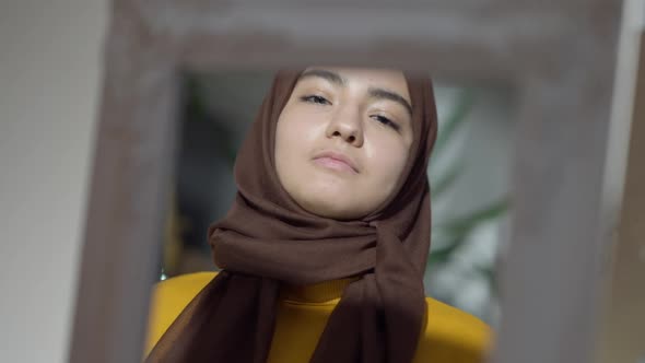 Closeup Reflection of Slim Charming Muslim Woman Adjusting Headscarf and Winking