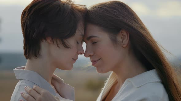 Lesbian Couple Touching Noses and Embracing Outdoors