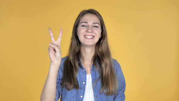 Victory Sign By Pretty Woman Isolated on Yellow Background