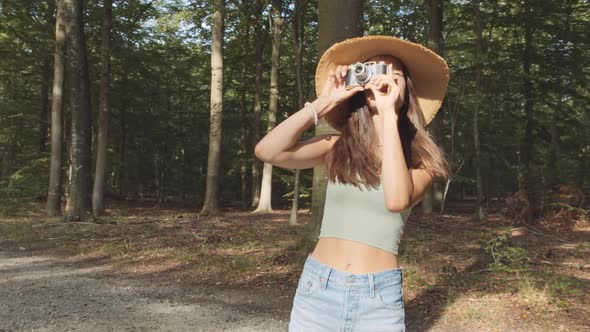 Teenage Girl Using Vintage Camera In Forest