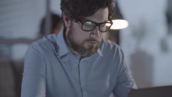 Bearded Man Working in Office Overtime