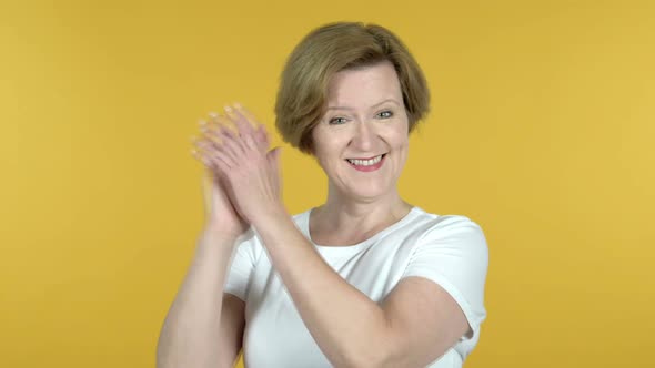 Clapping Old Woman Applauding Isolated on Yellow Background