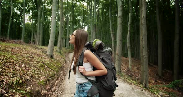 Backpacked Woman Walking in Forest