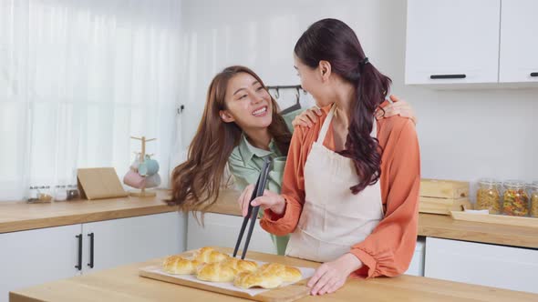 Asian beautiful lesbian woman couple look at girlfriend bake croissant.