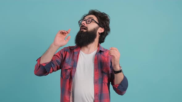 Close Up of a Sick Man Sneezing. Bearded Man Isolated on Turquoise Background.