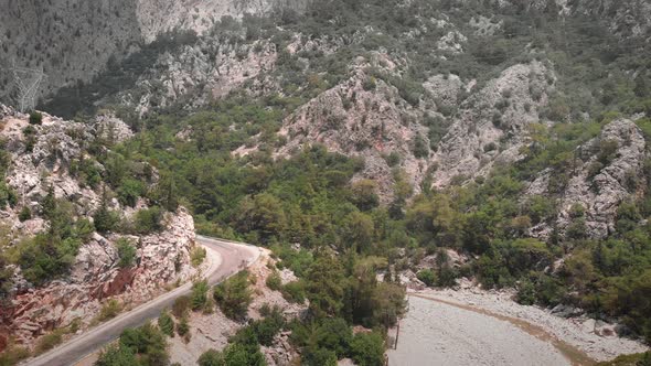 Mountain canyon between two green rocky mountains with winding car road