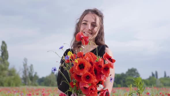 Portrait Adorable Young Woman Holding Bouquet of Flowers in Hands Looking in the Camera Standing in