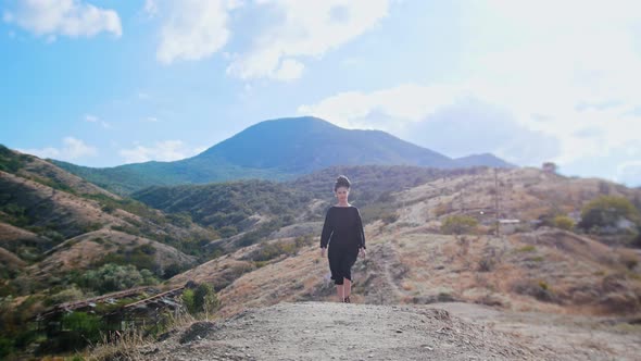 Adventure Trip  Young Woman Walks on the Mountain and Waving Her Hand to the Camera