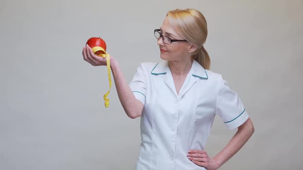 Nutritionist Doctor Healthy Lifestyle Concept - Holding Organic Red Apple and Measuring Tape