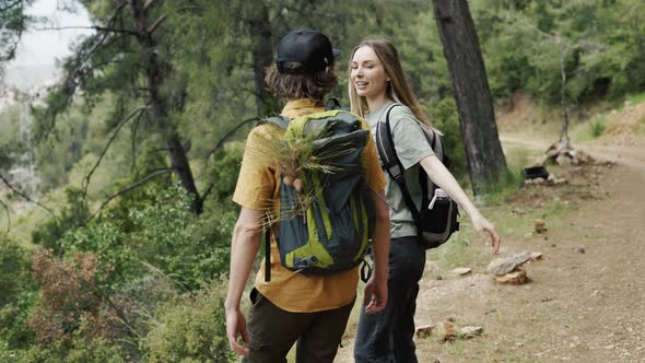 A Happy Couple Backpackers Hiking By Forest Exploring New Places
