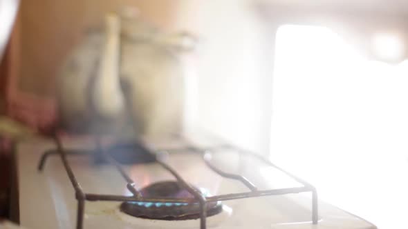 Person putting pan on gas stove