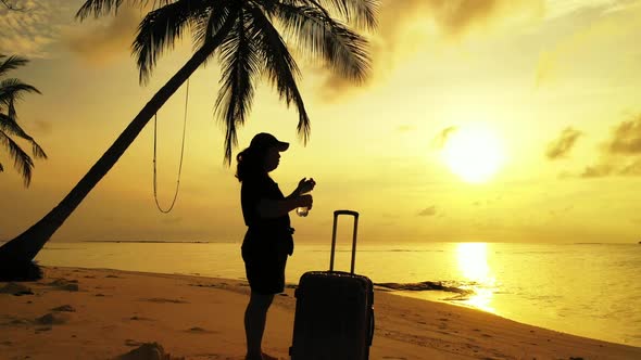 One girl happy and smiling on exotic resort beach voyage by aqua blue water and bright sandy backgro