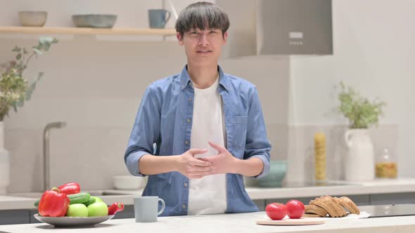 Young Asian Man Doing Video Call While Standing in Kitchen