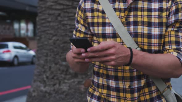 Caucasian male smiling and using his phone on a bike in a street