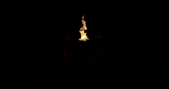 Fire Breathing Man Is Waving Two Burning Torches in Darkness