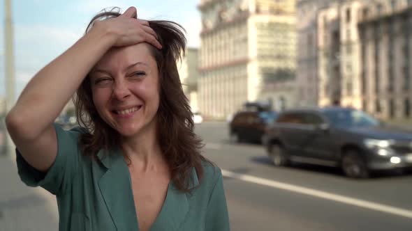 Portrait of a Happy Middle-aged Woman with Brown Hair, Walking Through the City Along the Highway