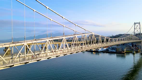 Drone scene of hercilio light suspension bridge revealing its structure and the city in the backgrou