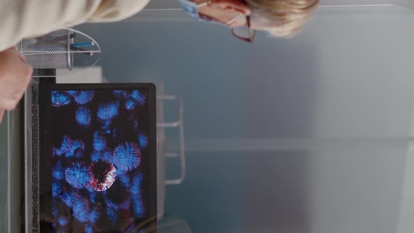 Vertical Video Health Specialist Showing Virus Illustration on Laptop to Old Woman