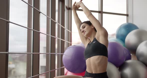 Athletic Woman Stretching on a Mat in a Fitness Studio