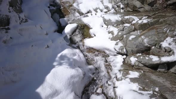 Flying over river in winter above waterfall