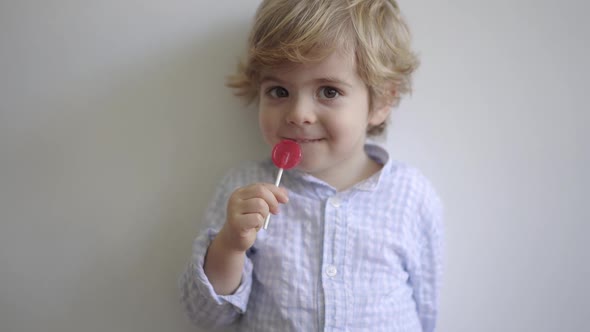 Cute boy enjoying sweet lollipop