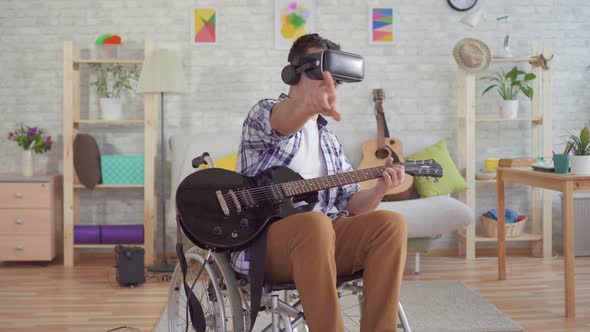 Portrait Young Man Disabled in a Wheelchair in Virtual Reality Glasses Musician Plays the Electric