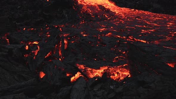 Glowing and incandescent lava river flowing in the night