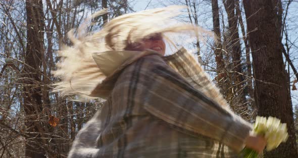 happy blonde girl spinning forest holding  bouquet flowers snowdrops her hands