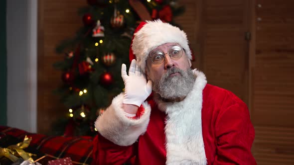 Portrait of Santa Claus Holding His Hand Near Ear Trying to Listen to Interesting News