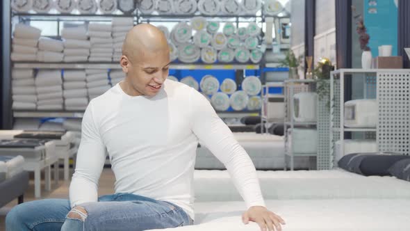 Attractive Man Trying New Bed at Furniture Store