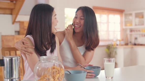 Young Asia lover girls happy using mobile phone talk with friend in kitchen.