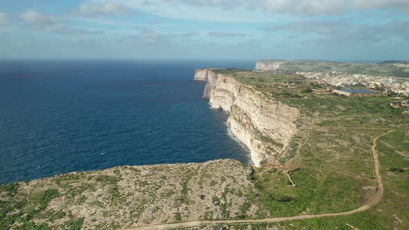 AERIAL: Beautiful Ta Cenc Cliffs Being Washed by Blue Mediterranean Sea on Windy Day
