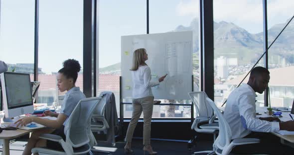 Woman writing on white board at the office