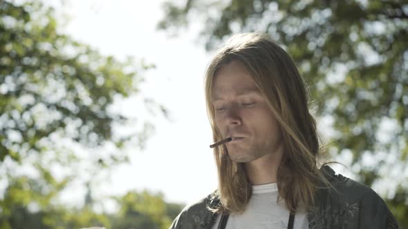 Young Caucasian Man Lighting Cigarette Sunlight Outdoors