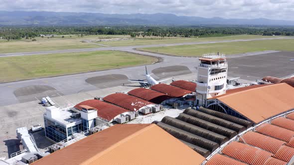 Aerial pan over Cibao airport terminal revealing aircraft runway, Caribbean